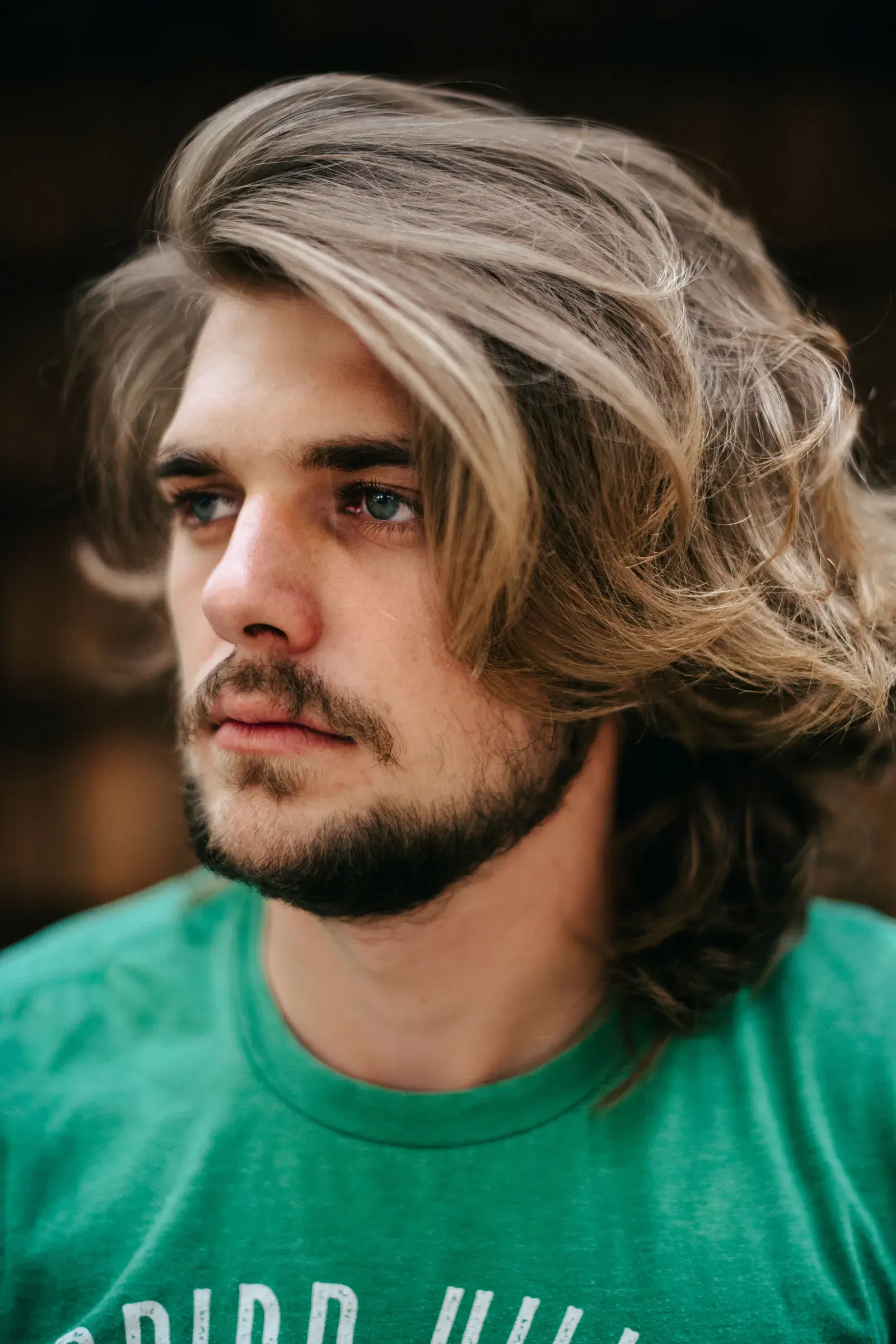 Man with long wavy hair and a beard, showing a men's wavy hairstyle